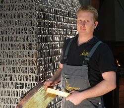 Kunstschmied Thomas Hoppen vor einem Modell des Schreins.